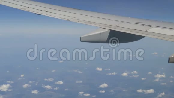 飞机飞过罕见的蓬松云从飞机机翼上的舷窗可以看到欧洲的田野视频的预览图