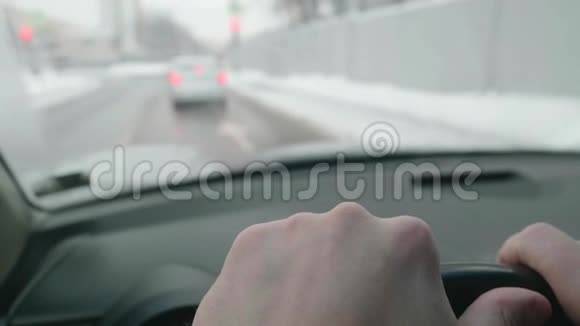 驾驶时两个司机的手都在方向盘上汽车驶近十字路口透过模糊的观点视频的预览图