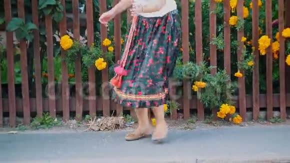 一个穿着长裙的女人在栅栏旁边的街道上跳舞腿视频的预览图