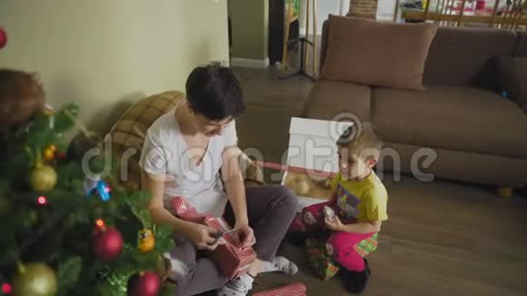 妈妈和儿子正在一起打包礼物家庭幸福和孩子一起活动视频的预览图