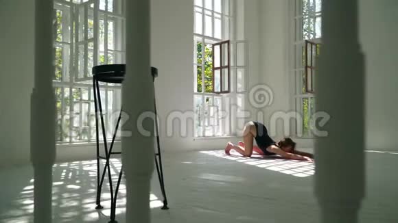 技能红发健康的白种人女人在白色的大房间里的垫子上练习瑜伽体育运动中的年轻妇女视频的预览图