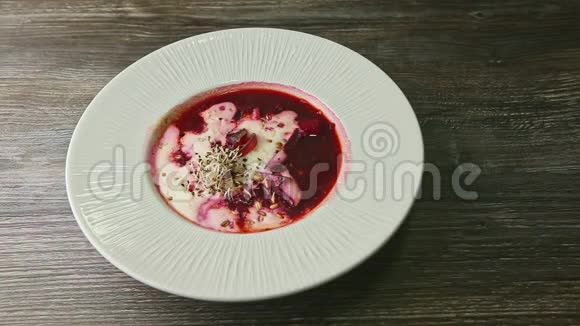 用传统的乌克兰罗宋汤和酸奶油装饰的人手旋转盘子视频的预览图