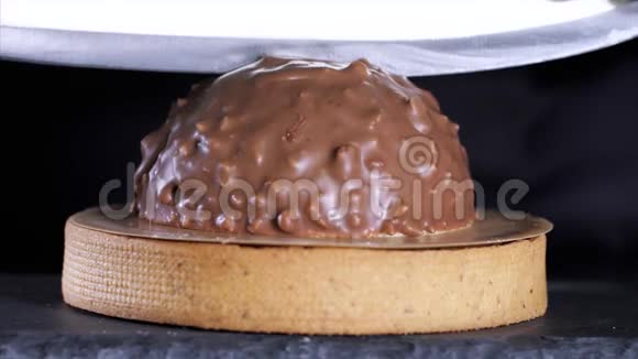 厨师的特写镜头是用牛奶巧克力和坚果切甜点视频的预览图
