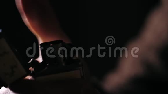 一只雄性手的特写在黑暗中点燃燃料打火机视频的预览图