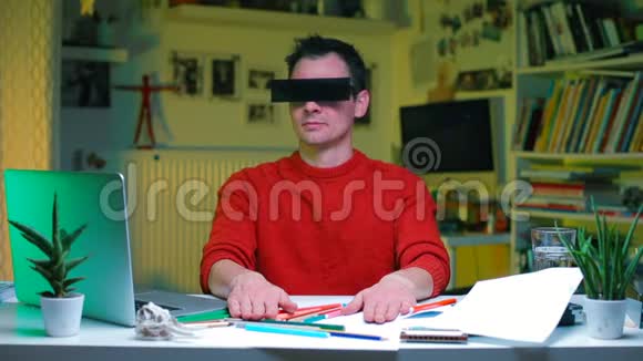一个穿红色衣服的人坐在办公室的桌子旁视频的预览图