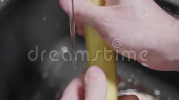 人的手在流水下洗黄色的香蕉然后把自来水关掉关闭并缓慢运动视频的预览图