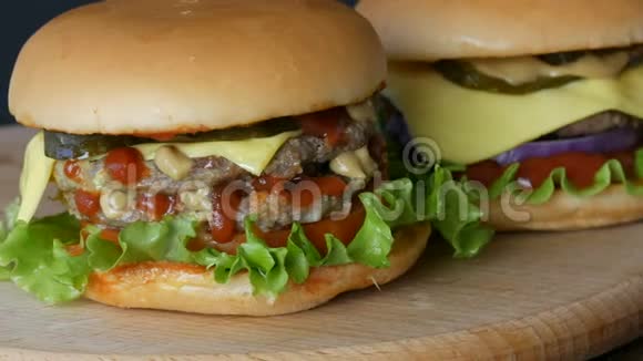 两份美味的大汉堡芝士汉堡或汉堡里面有一片多汁的生菜叶一片番茄奶酪和一块肉视频的预览图