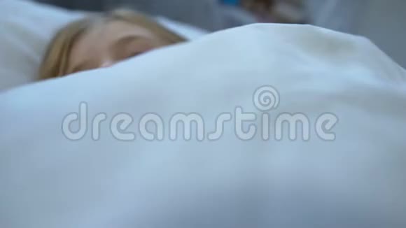 戴着围巾的小金发女孩睡在床上感觉不舒服感染了流感病毒视频的预览图