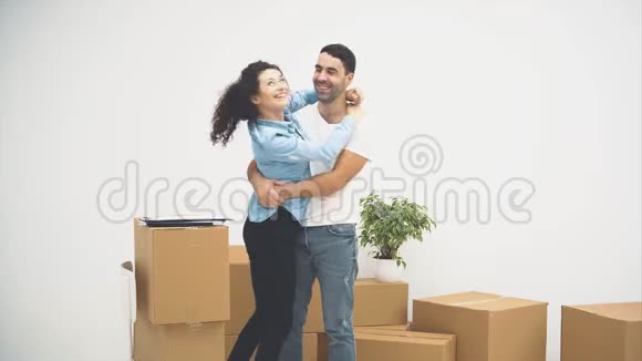 年轻夫妇正一起搬到一间新公寓拥抱和依偎的一对他们注意到箱子上有一些文件视频的预览图