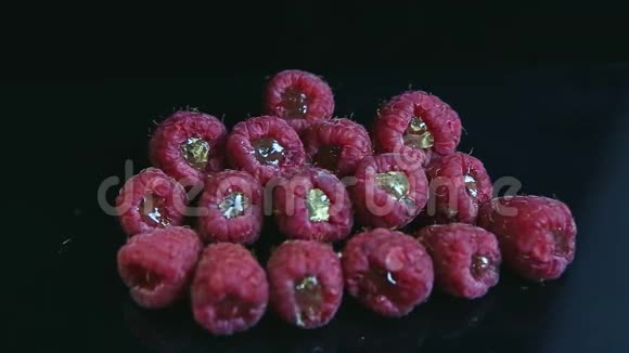 黑色背景下一堆装满果冻的新鲜全树莓视频的预览图