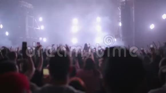 音乐摇滚音乐会上的人们正在享受乐趣并及时向音乐挥手俱乐部气氛橙白色的光线视频的预览图
