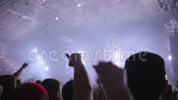 音乐摇滚音乐会上的人们随着音乐及时挥手俱乐部气氛橙白色光线视频的预览图