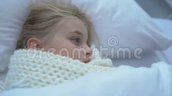 母亲裹着围巾躺在生病的小女儿身边抚养孩子格里普或流感视频的预览图