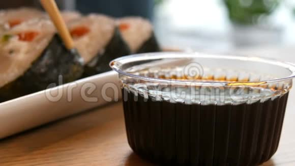 大寿司卷三文鱼在诺里螃蟹棒黄瓜费城奶酪蘸酱油碗视频的预览图