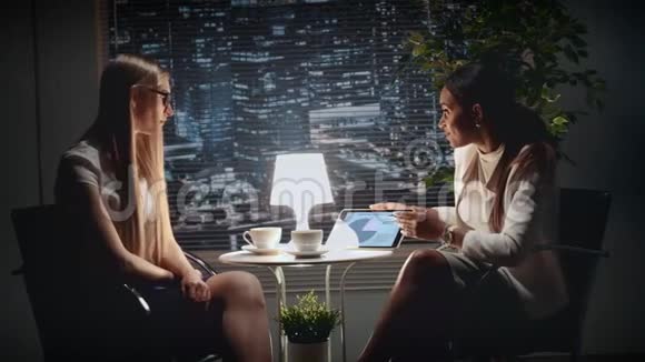 两个多种族的女商人用桌子讨论她们的工作成果视频的预览图