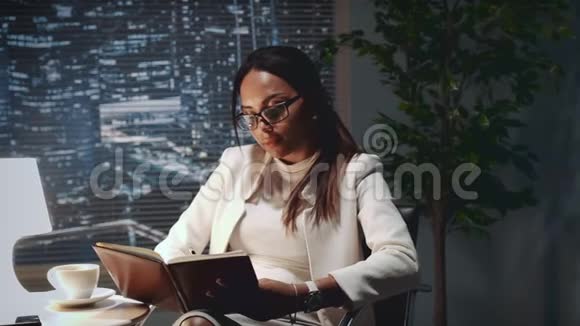 混合种族的商业女孩在办公室的笔记本上做笔记视频的预览图