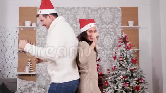 白人夫妇在圣诞节装饰的房间里玩得开心跳舞视频的预览图
