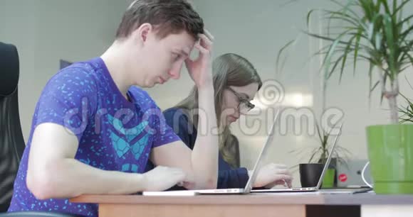 办公室里有三个使用电脑的年轻人两位设计师同事携手创新视频的预览图