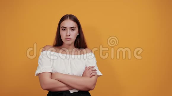 严肃的年轻女子停下脚步在橙色的墙上摆出一副孤立的姿态视频的预览图