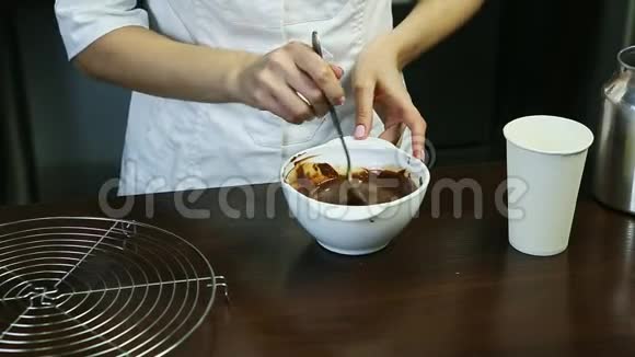 厨师统一配置的甜点在深白碗中配制液体巧克力釉视频的预览图