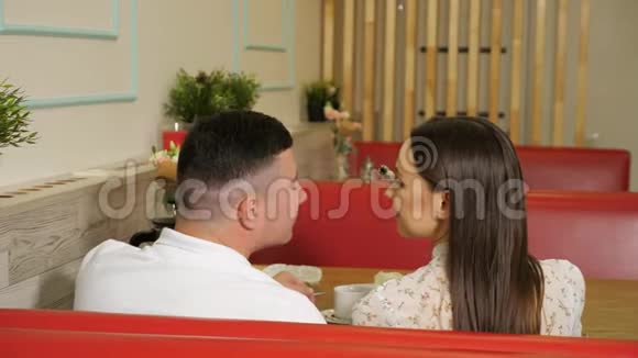 年轻女孩假装在餐桌上喂男人吃蛋糕视频的预览图