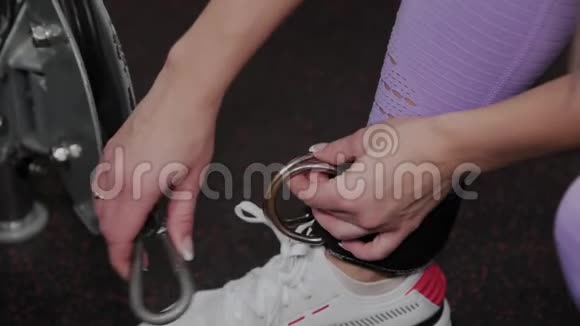 运动的女人一个漂亮的身材把她的腿贴在健身房的一台块运动机上视频的预览图