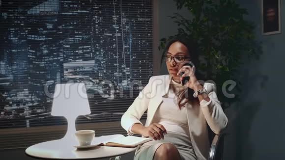 非裔美国商业女性戴眼镜用智能手机说话视频的预览图