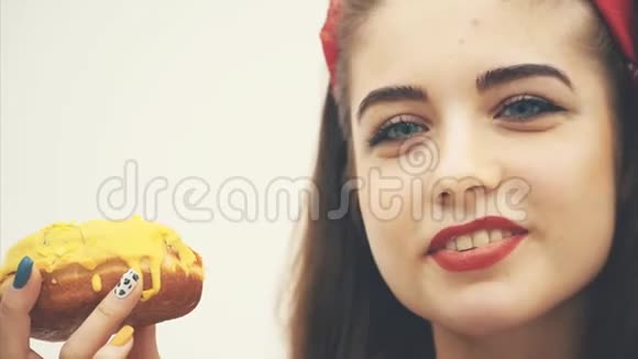 一个可爱的小女孩的嘴脸诱人地品尝着美味的黄色甜甜圈微笑着开心的脸视频的预览图