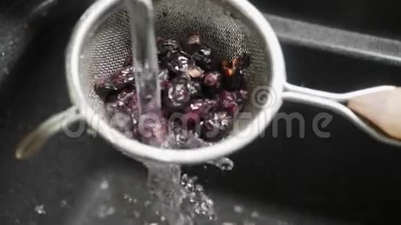 干玫瑰花在流水下过水槽手摇过滤器清洗每一个浆果慢动作视频的预览图