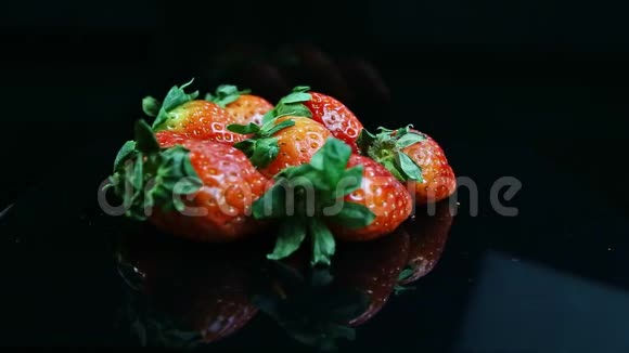 一组新鲜多汁的红草莓呈黑色视频的预览图