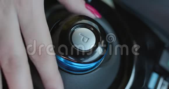 手指按下按钮驱动或反转女人的手在车里按下反向齿轮按钮视频的预览图