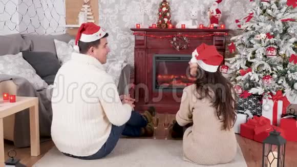 一对夫妇在圣诞前夜在壁炉前喝香槟视频的预览图