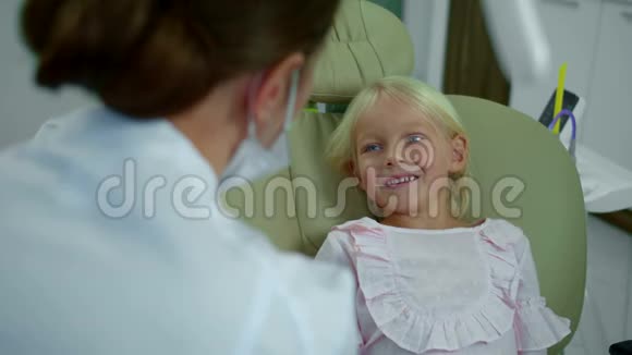 小女孩和牙医说话指着她的脸和嘴视频的预览图