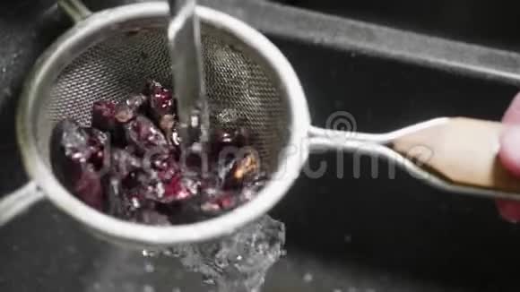 干玫瑰花在流水下过水槽手摇过滤器清洗每一个浆果慢动作视频的预览图