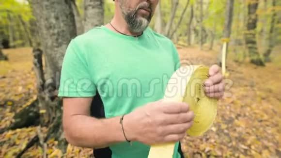 在秋天的森林里一个大胡子的人在学习完一课后会收集一条松弛的绳子视频的预览图