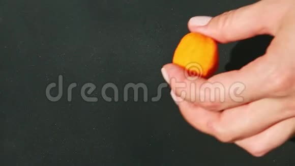 上景特写女人手拿一小块橙色的杏仁糖视频的预览图