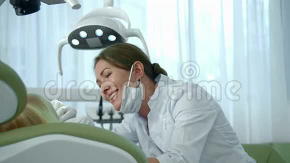 医生看着女孩的牙齿继续和她说话视频的预览图
