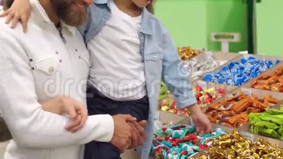 年轻的父母在超市给女儿买糖果视频的预览图