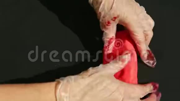 上景特写女性双手捏大块鲜红的杏仁视频的预览图