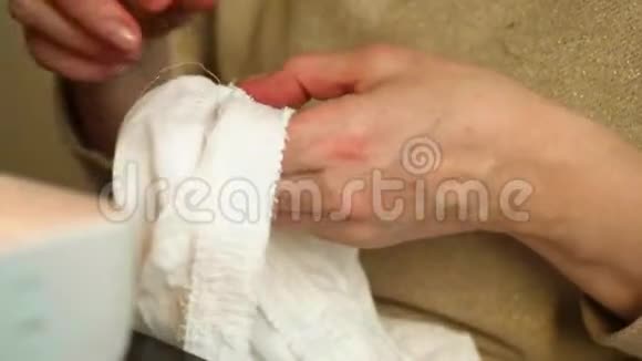 聚精会神的女人用雀斑双手从一块布上抽出纤维视频的预览图