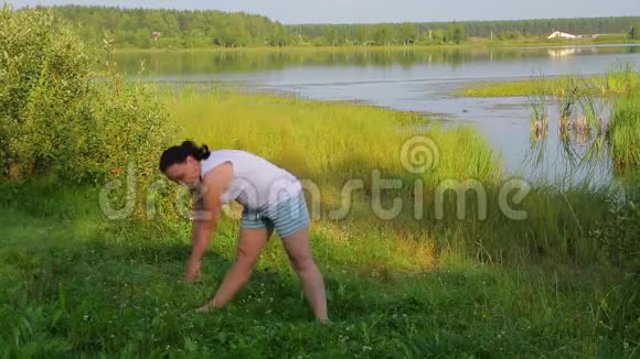 布鲁内特女士早上在湖边做倾斜练习视频的预览图