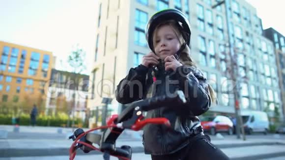 小女孩在街上固定安全帽骑自行车运动和爱好视频的预览图