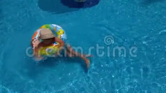 男孩漂浮在游泳池里的充气圈上慢动作视频视频的预览图