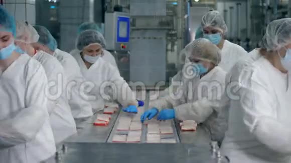 女食品厂工人进行的鱼小吃包装过程视频的预览图