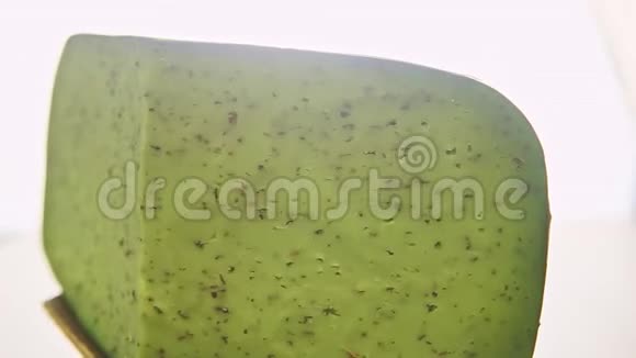 一大块绿色奶酪和草药在小盘子上旋转视频的预览图