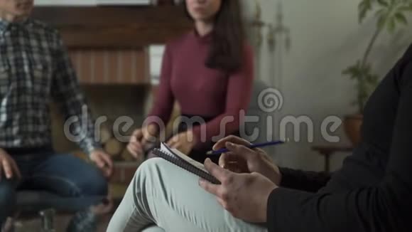 模糊的年轻女人在后台对她的配偶大喊大叫男性白种人的手在前台写下视频的预览图