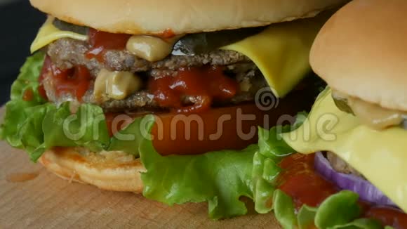两份美味的大汉堡芝士汉堡或汉堡里面有一片多汁的生菜叶一片番茄奶酪和一块肉视频的预览图