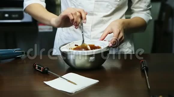 大勺液体巧克力釉在深白碗中搅拌糖果视频的预览图