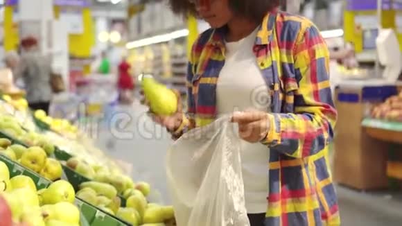美丽的非洲裔美国妇女有非洲发型在超市买水果视频的预览图