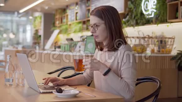 严肃的女人专心看着班长在咖啡馆的桌子上喝茶视频的预览图